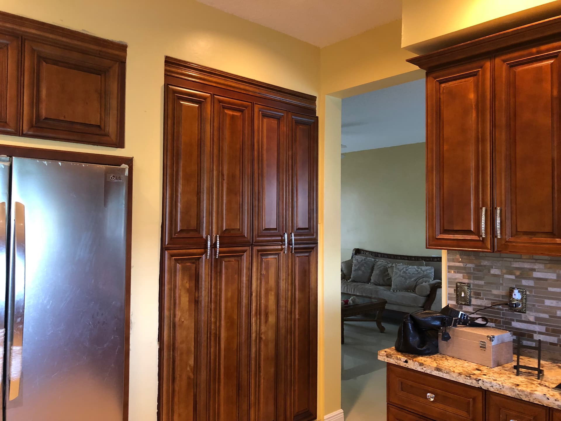 Completed full height pantry cabinetry beside stainless refrigerator