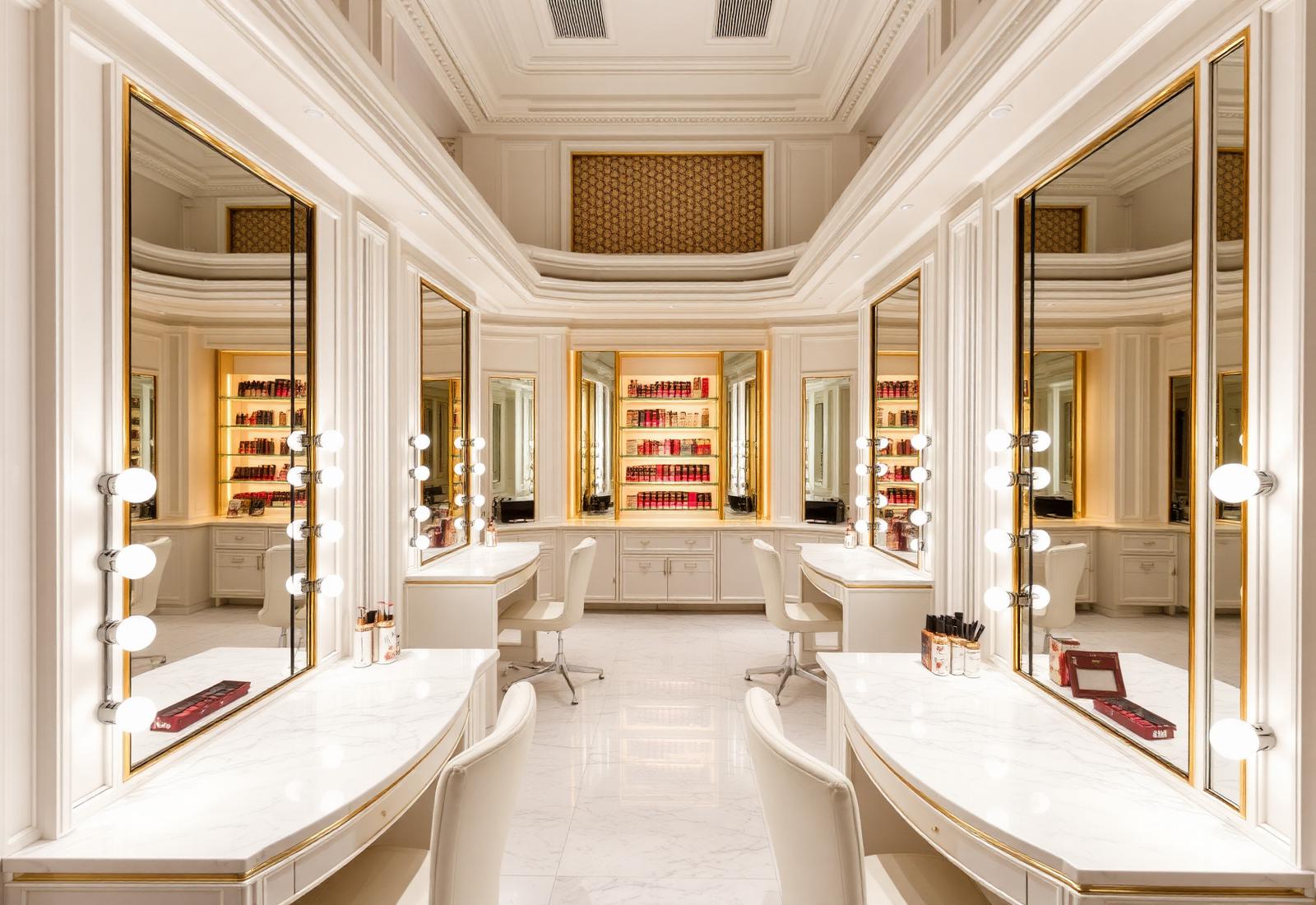 Makeup studio with professional illuminated mirrors, marble vanities and gold detailing